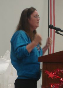 Photo of a woman standing at a podium and speaking.