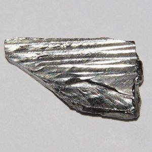 A single piece of tantalum, about 1 cm in size. This mineral is silver in color. It is used in cell phone technology.