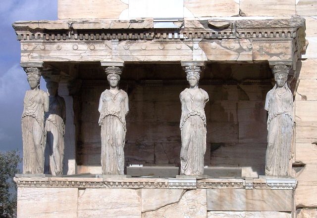 View of an ancient Greek temple; six marble sculptures of female figures hold up the entablature