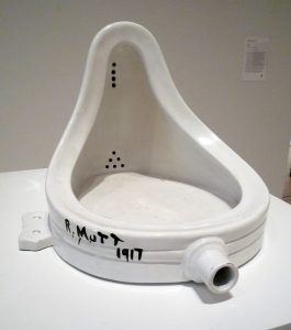 White porcelain urinal on its back on a pedestal. Signed R. Mutt and dated 1917.