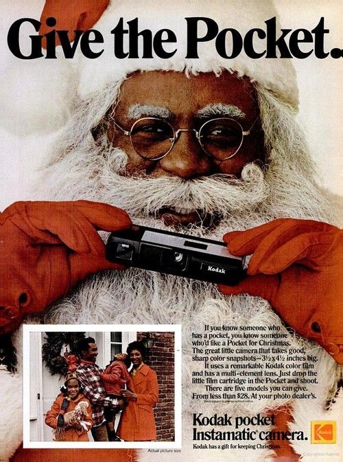 An an advertisement for a Kodak pocket instamatic camera. The text as the top reads "Give the Pocket." A photograph of the face of a dark-skinned Santa Claus fills the page holding a camera with red-gloved hands. A photograph of a family in winter attire occupies the lower left corner with text to the right promoting the camera.