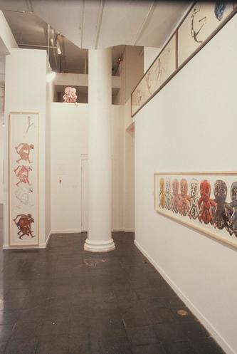 Photograph of a gallery space with a column and prints on the walls.