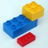 three Duplo building blocks of varying size and color