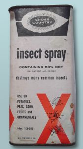 An old, beaten up, metal bottle of pesticide. Insect spray containing 50% of DDT.