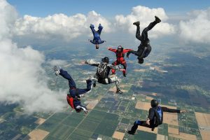 A group of skydivers falling in various body orientations previous to opening parachutes