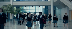 Two teenagers walk down a school corridor