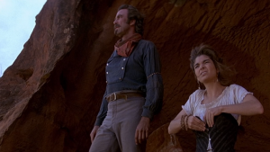 Screen snip of Quigley and Cora looking out upon the desert