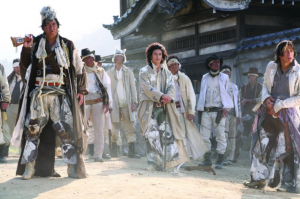 A group of armed characters standing on a dusty road