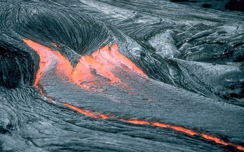 Image shows lava flowing from Kilauea Volcano, Hawai`i.