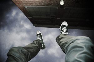 a photo titled &quot;Falling Upside Down&quot; shows a person's legs and feet upside down next to a building with the sky visible beyond their feet