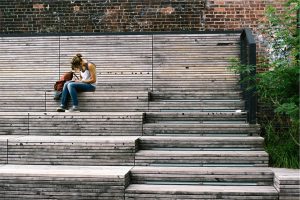 student sitting on bleachers doing homework