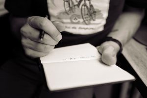 close up photo of a person writing on a notepad