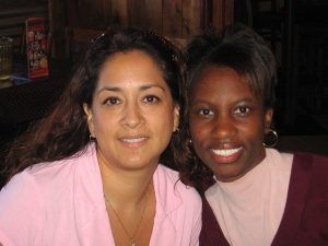 Two women from different racial backgrounds smiling together.