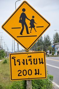 A sign showing people crossing the street in Thailand.
