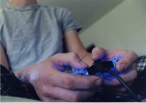 Teenager holding a controller, playing a video game.