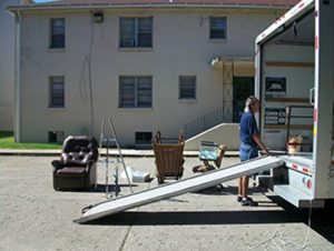 A person unloading furniture from a moving truck.