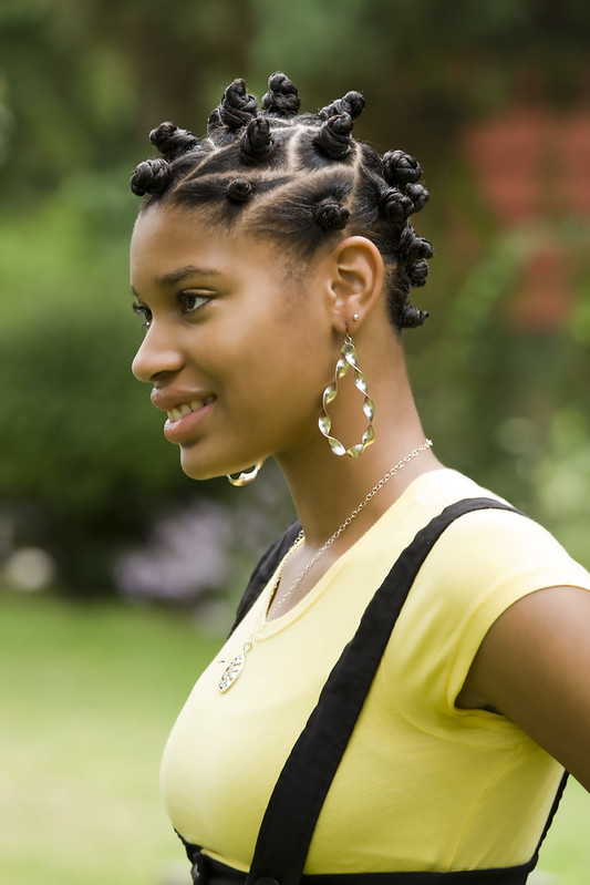 A person with their hair in a traditional set of knots around her head