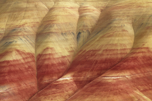 Image of the painted hills in Oregon. Layers of red, yellow, and black rock.