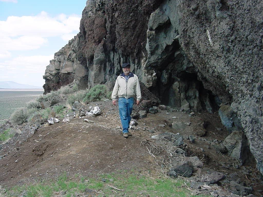 man walking near cave