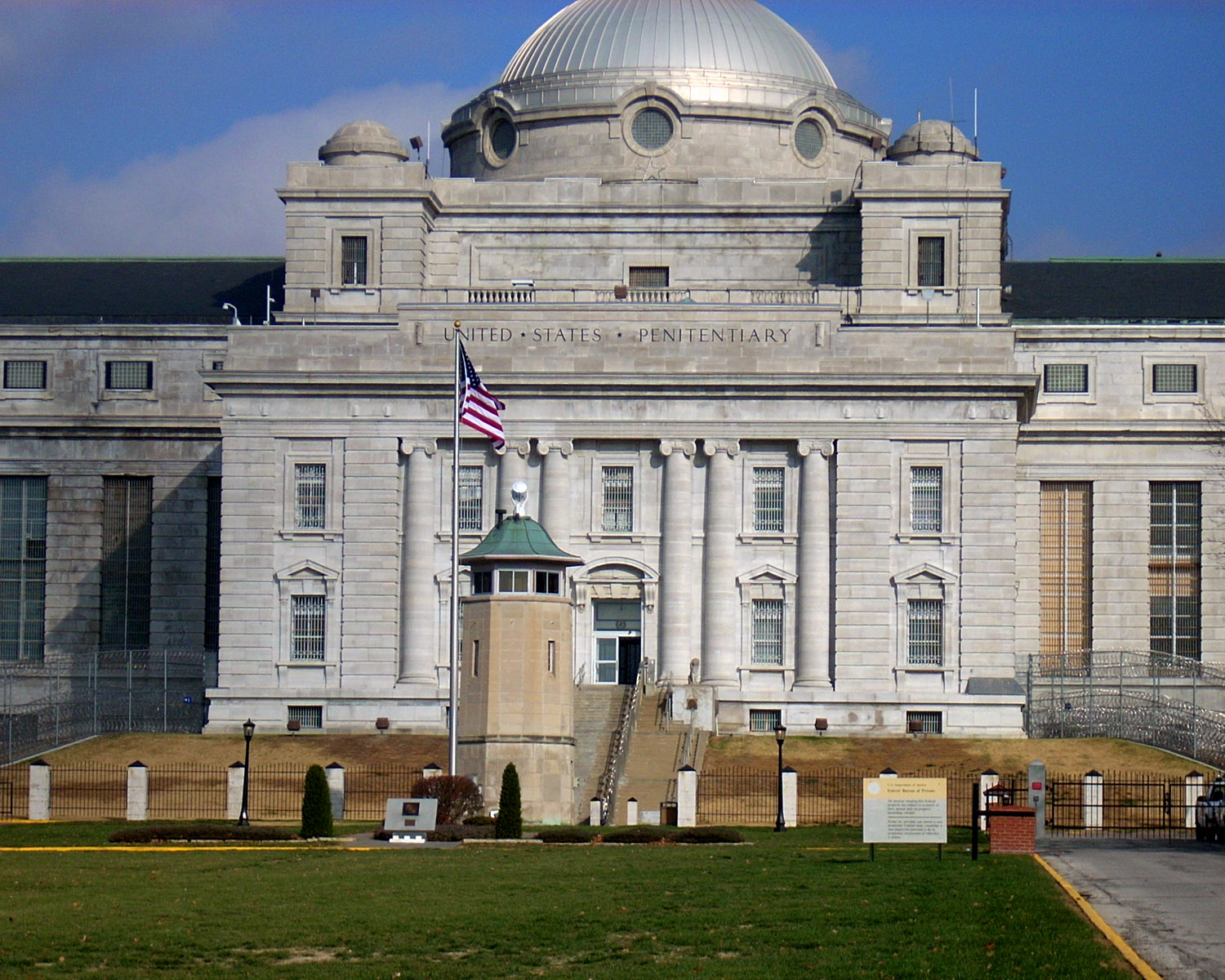 A fancy domed building with a guard tower and American flag in front.