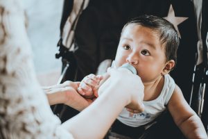 A baby drinking formula from a bottle