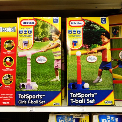 T ball sets on store shelf. One is labeled as girls t-ball set and is pink.