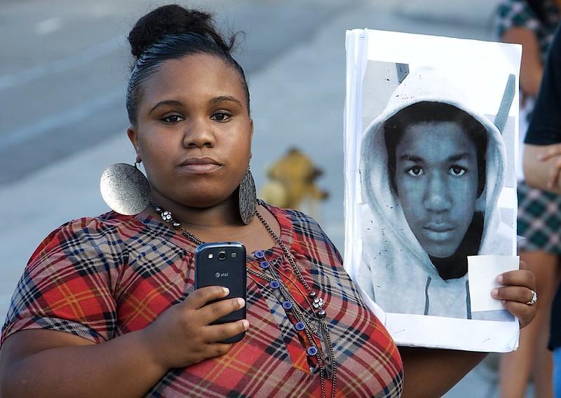Person holds an image of Trayvon Martin