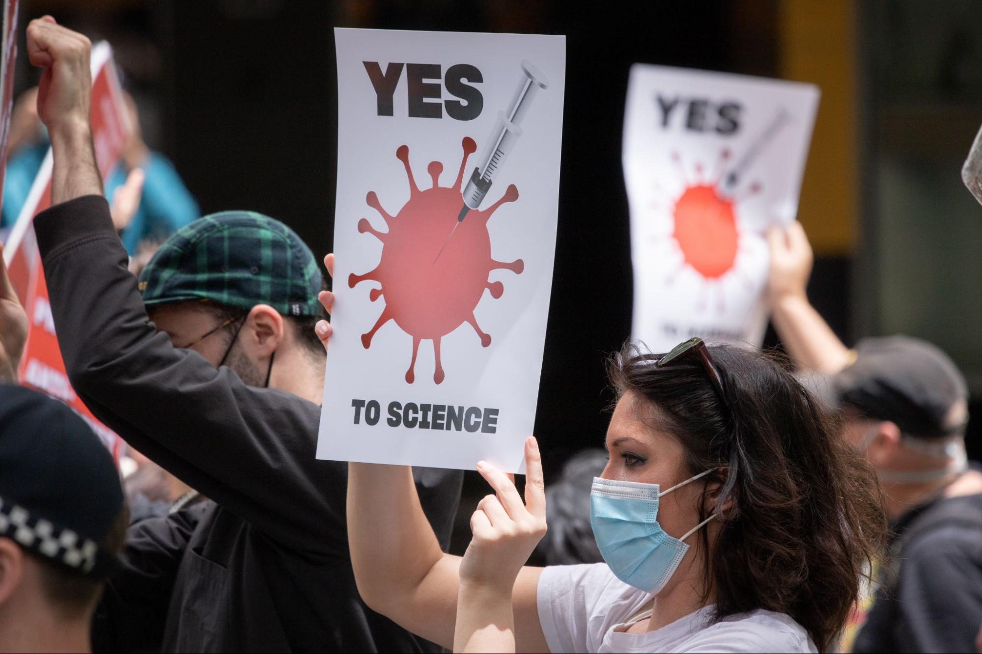 Protesters hold signs that read, "Yes to science."