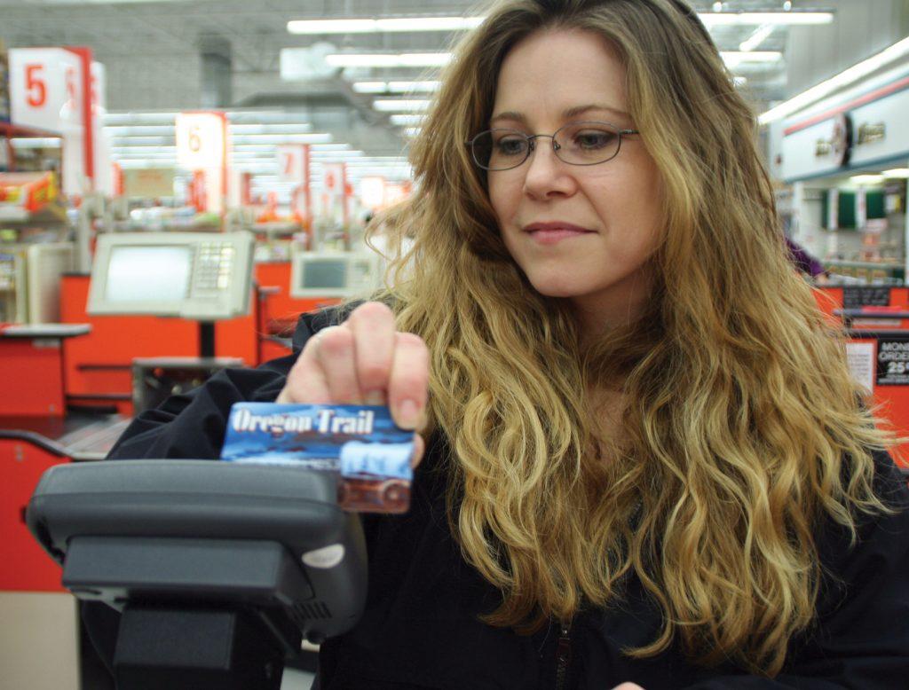 Electronic card reader and woman holding SNAP card