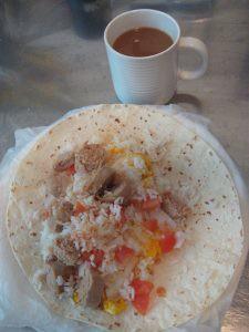 tortilla with meat, rice, tomatoes and a cup of coffee