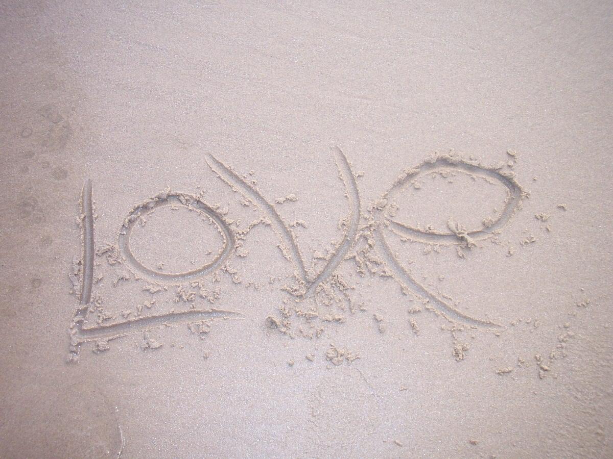 The word love written in the sand.