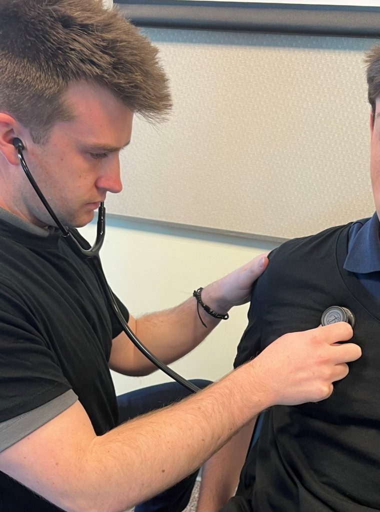 A person using a stethoscope to listen to a patient's anterior right upper chest, right upper lobe.