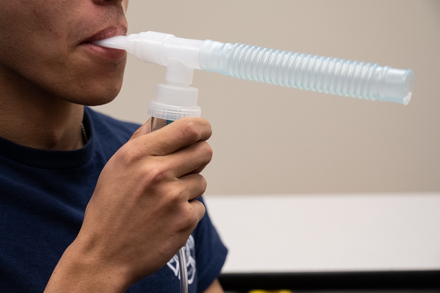 A patient holding a nebulizer in their mouth