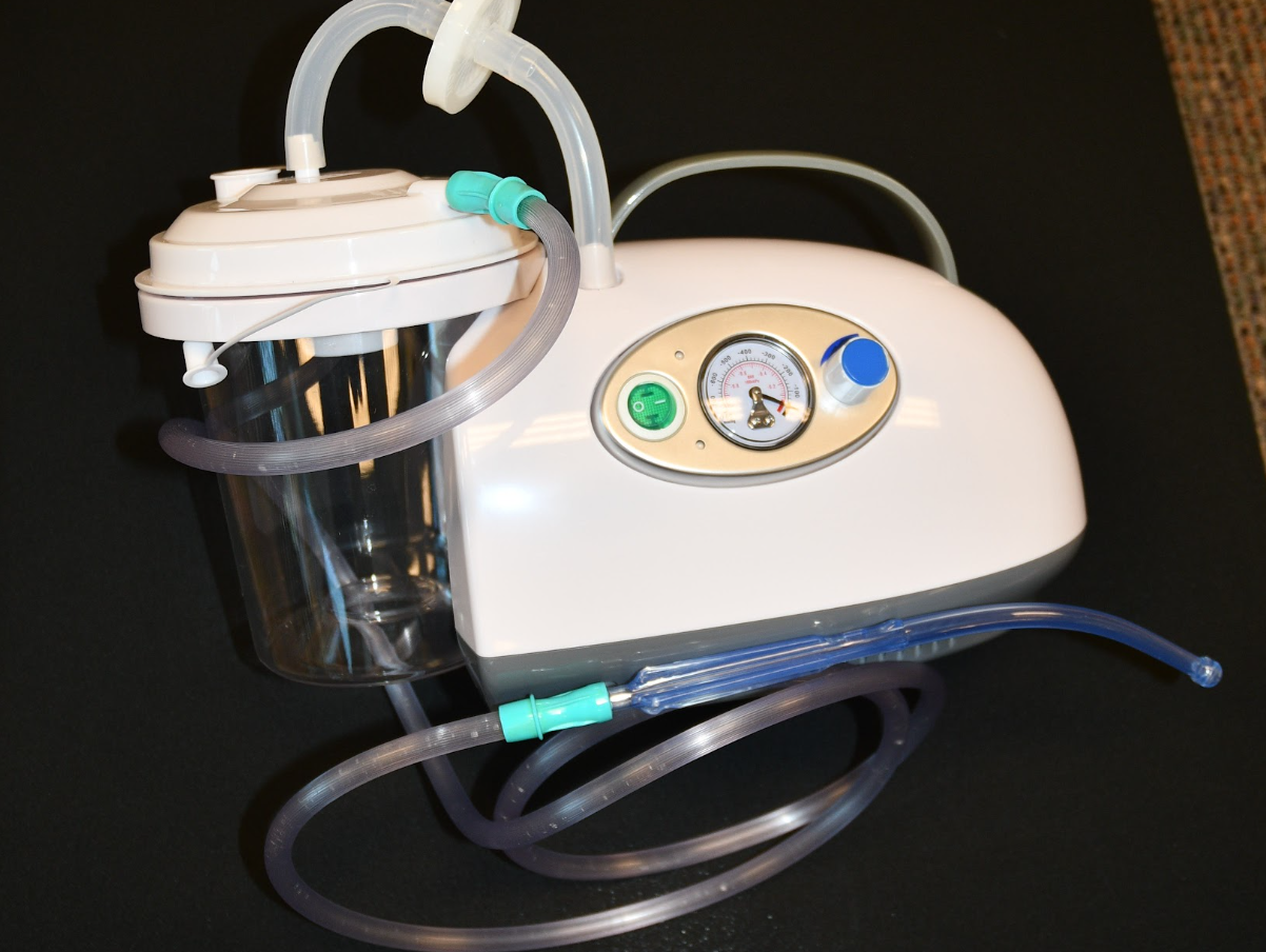 Photo of portable suction unit with suction tubing and attached tonsil tip catheter.