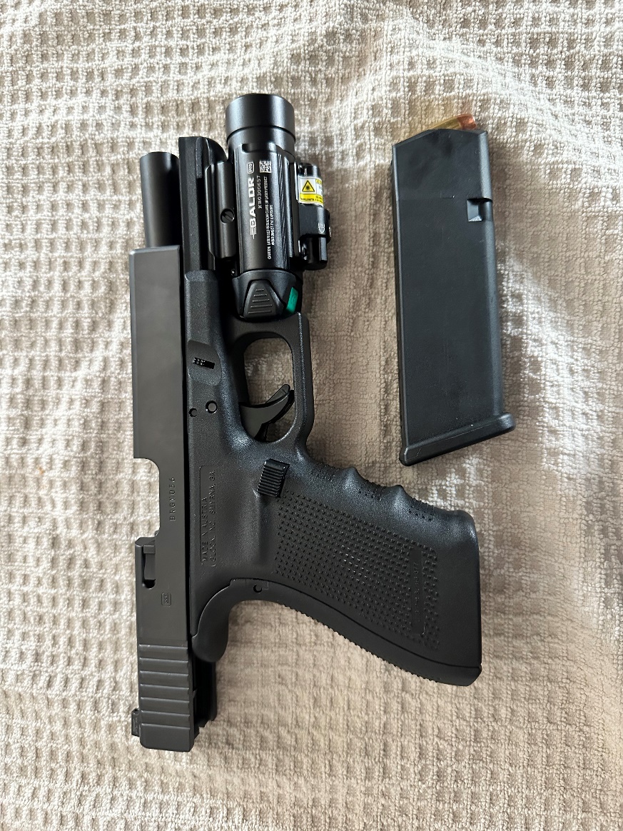 An semi automatic handgun with a magazine and a flashlight.