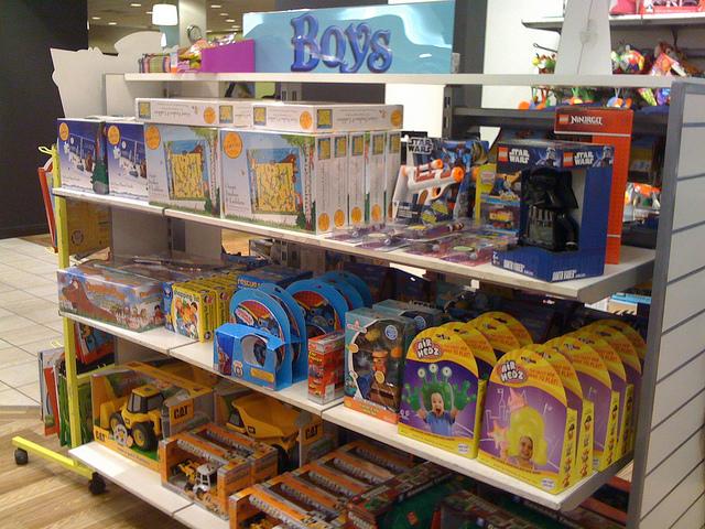 Store display of boys' toys, including Star Wars action figures and construction vehicle models.