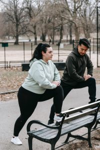 two people stretching on a bench