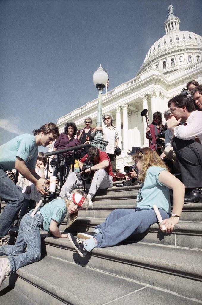 Disabled people, including 8 year old Jennifer Keelan, crawl up the steps to the US capital