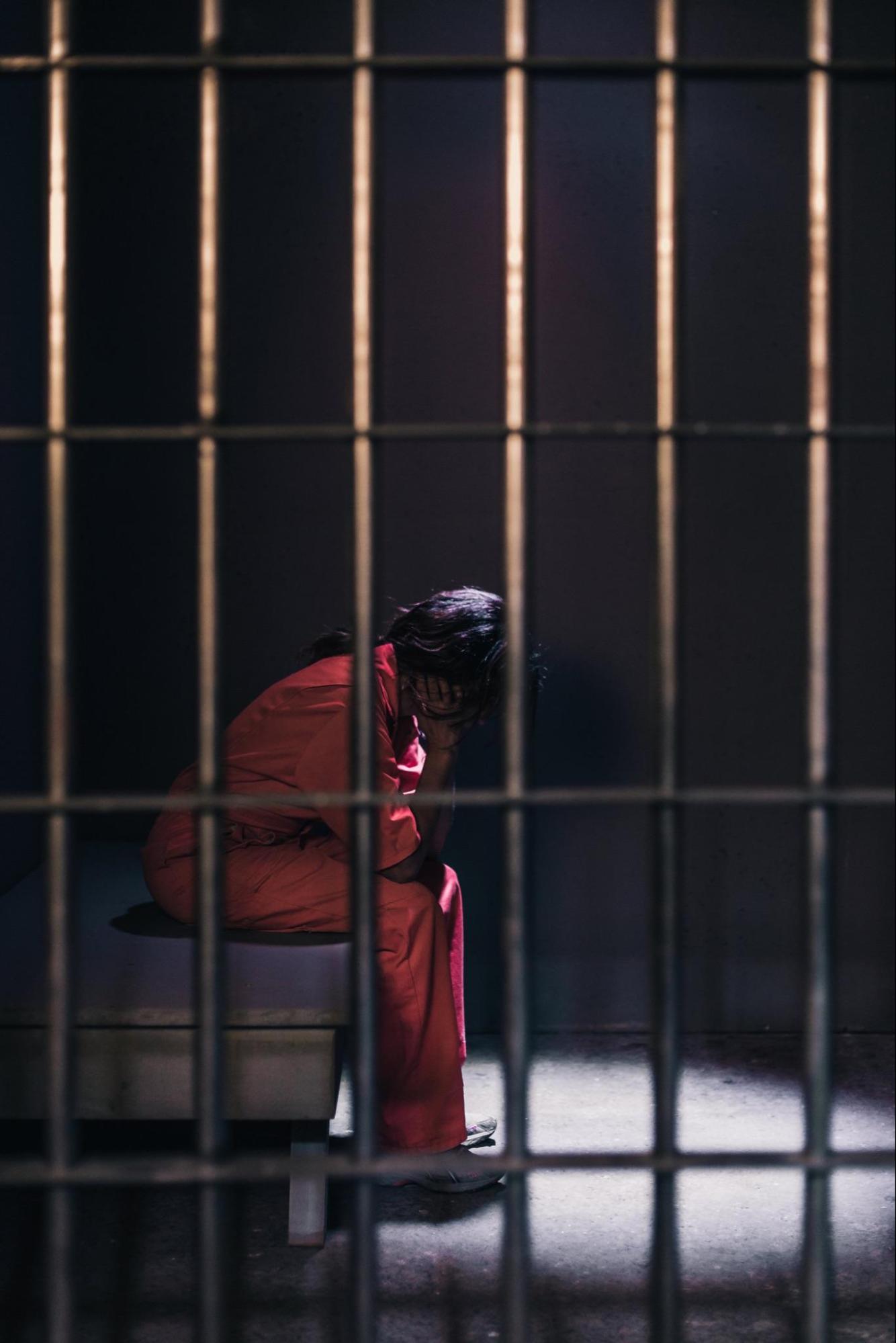 A person sitting in a jail cell