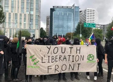 A large banner labeled Youth Liberation Front is being held by many people. The picture doesn't show their faces clearly.
