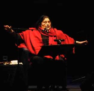 Mercedes Sosa sings while looking down, with arms spread open