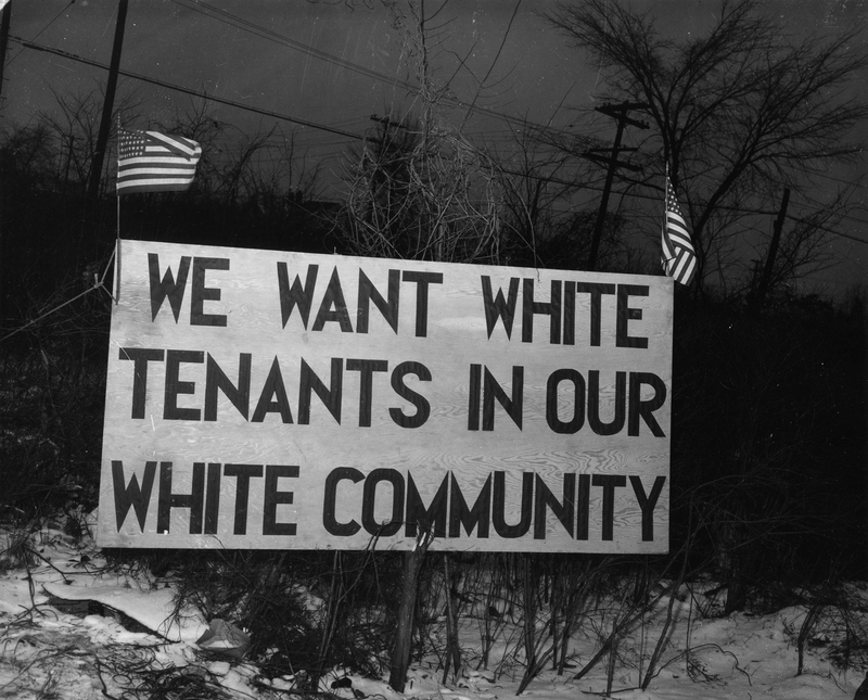 A historic photo depicting a roadside sign that says "we want white tenants in our white community"