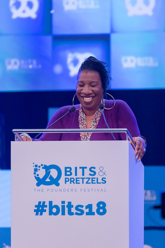 Tarana Burke speaks into a microphone at a podium at the Bits & Pretzels conference in Munich, Germany