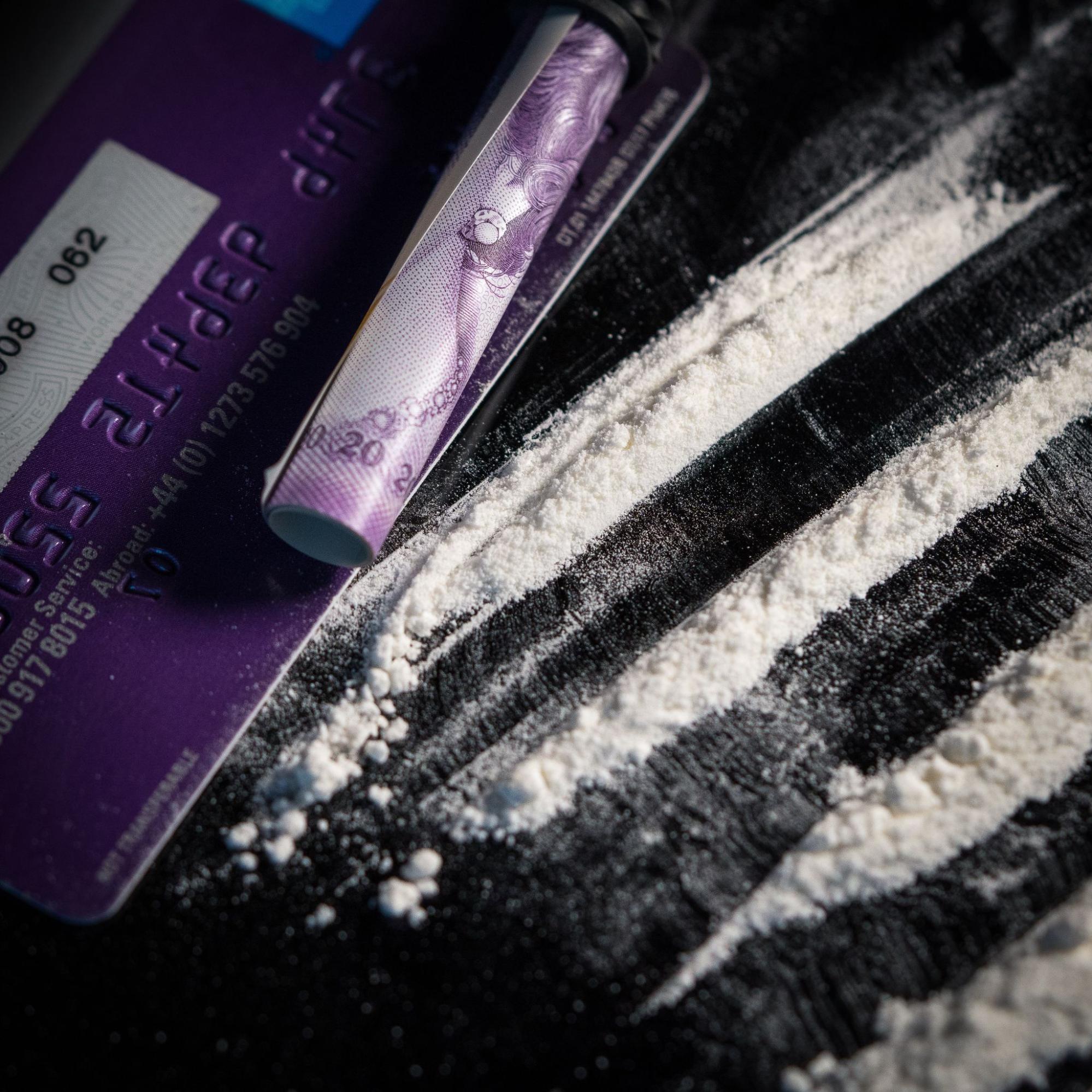 Fig 8.4 picture of white cocaine powder, rolled up money, and other tools used in cocaine use