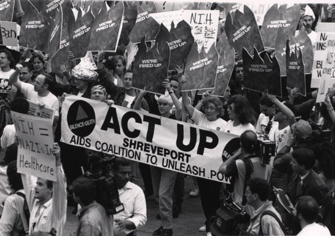 Photograph of people holding signs and marching.