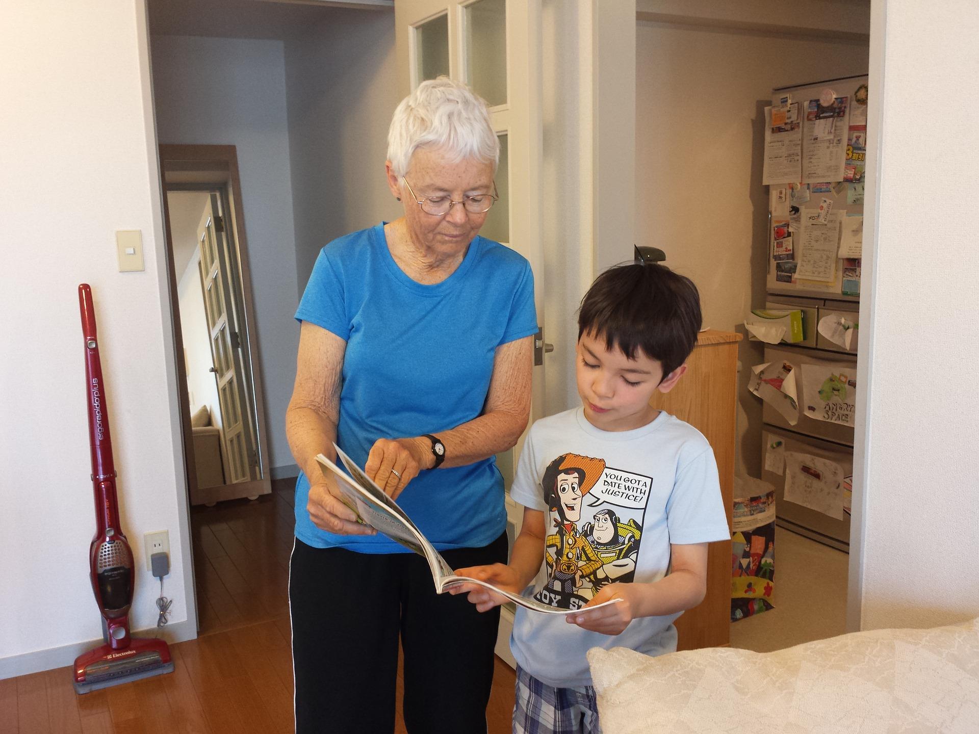 An older person talking to a younger person and pointing to a magazine.