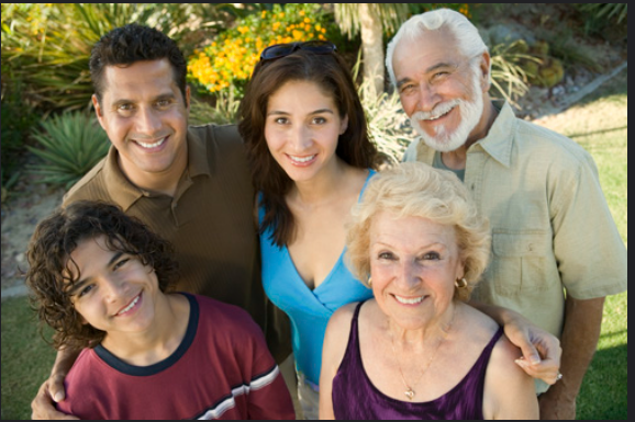 Children, parents, and grandparents embracing and smiling in a family photo.