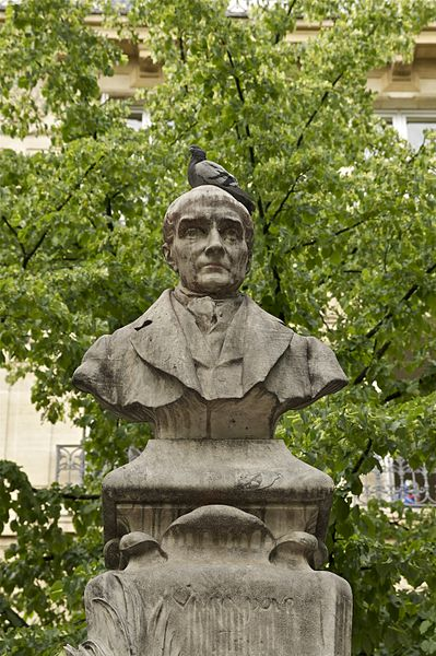 Statue of Comte in Place de la Sorbonne in Paris, with a bird sitting on his head.