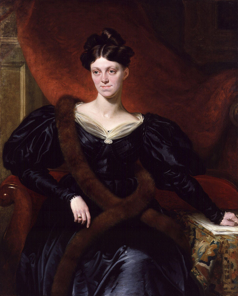 Portrait of Harriet Martineau by Richard Evans, a white woman with a dark purple dress, sitting in front of a red backdrop.