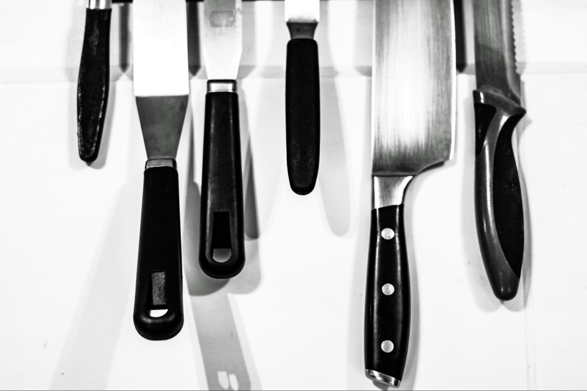 Kitchen knives and spatulas hanging on a wall